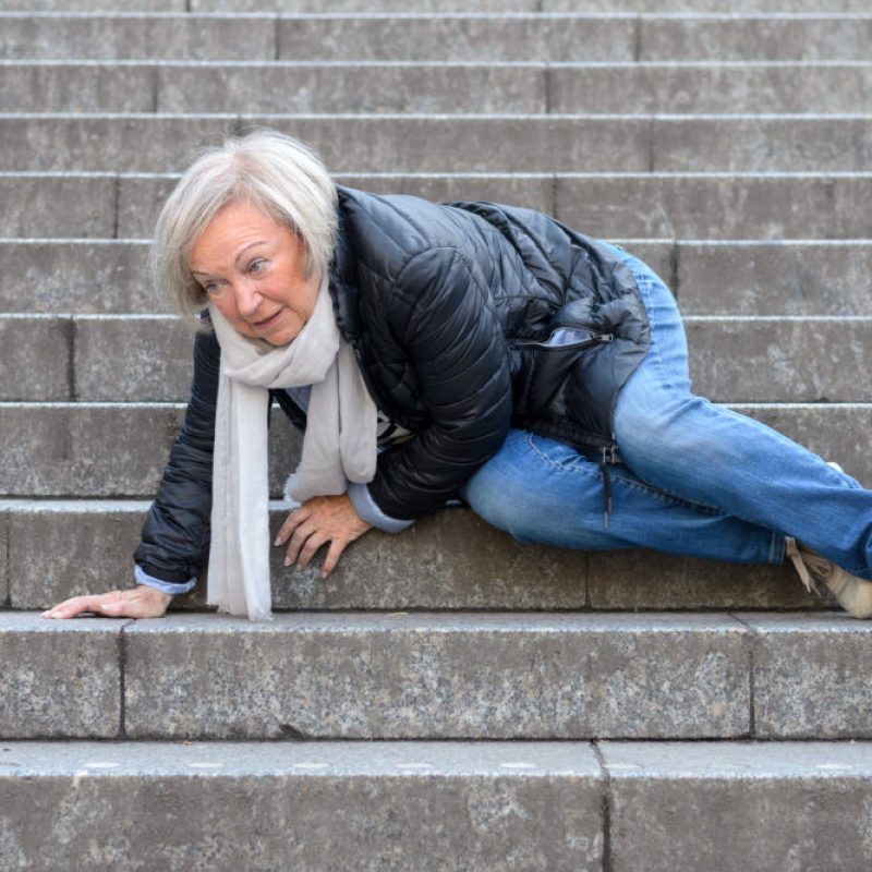 Senior woman accidentaly falling down stone steps outdoors